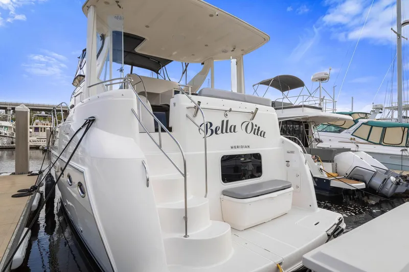 Slide: The Image of 2008 Meridian 408 Motoryacht docked, featuring "Bella Vita" on the stern, under a clear blue sky. - 52