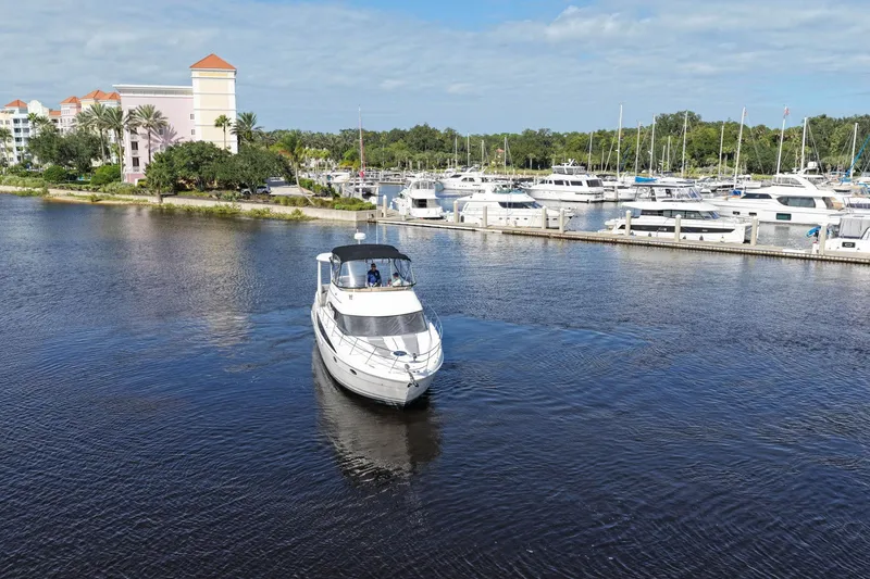 Slide: The Image of 2008 Meridian 408 Motoryacht cruising near marina with docked boats and waterfront buildings. - 57