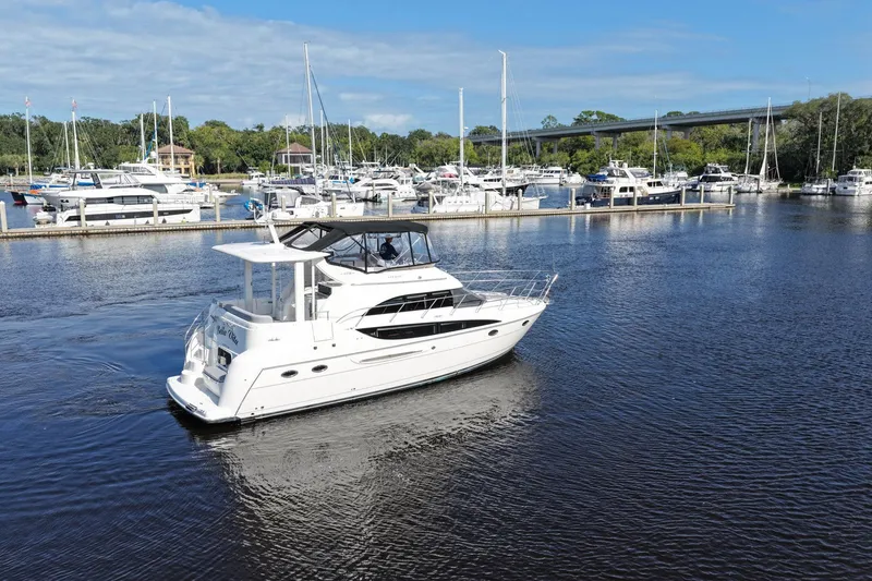Slide: The Image of 2008 Meridian 408 Motoryacht cruising in a marina with docked boats. - 58