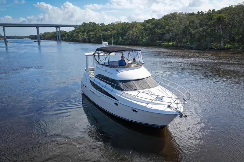 Slide: The Image of 2008 Meridian 408 Motoryacht cruising on a scenic river with a bridge in the background. - 61
