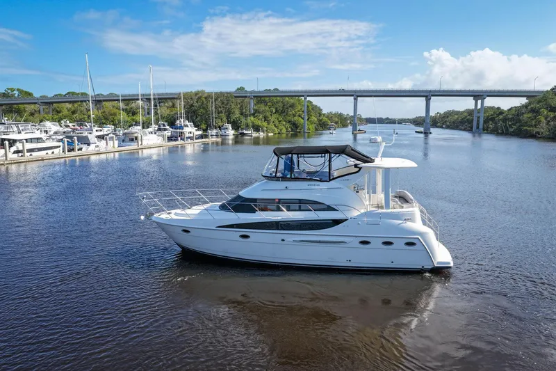 Slide: The Image of 2008 Meridian 408 Motoryacht cruising on a serene river under a clear blue sky. - 64