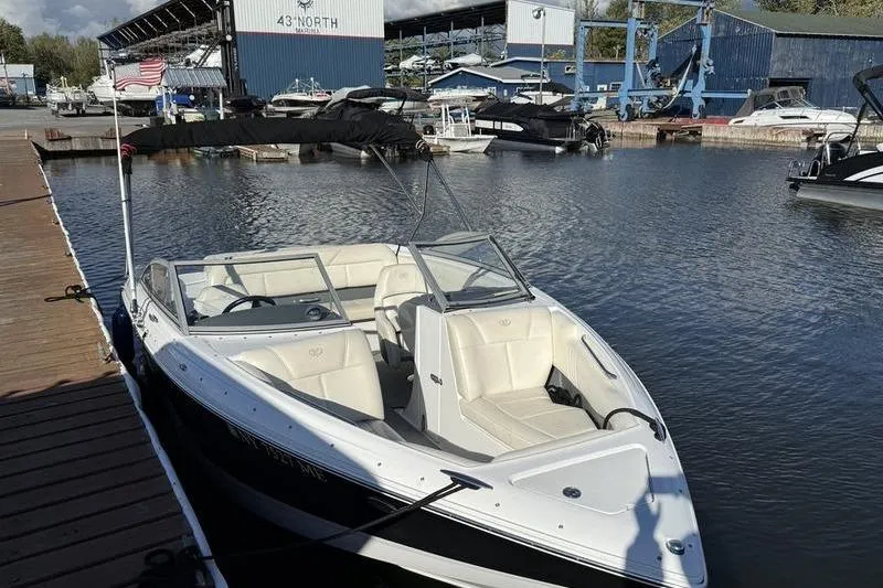 The Image of 2008 Cobalt 202 boat docked at marina with American flag, clear sky, and calm water. - 0