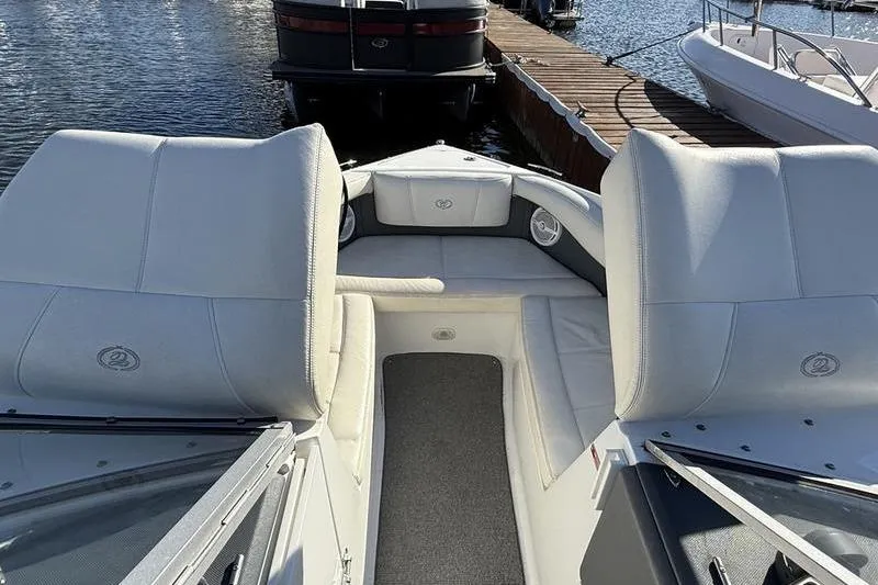 Slide: The Image of 2008 Cobalt 202 boat interior with white seating, docked by the water. - 14