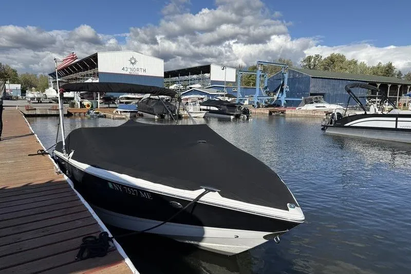 Slide: The Image of 2008 Cobalt 202 boat docked at marina with covered deck, under partly cloudy sky. - 3