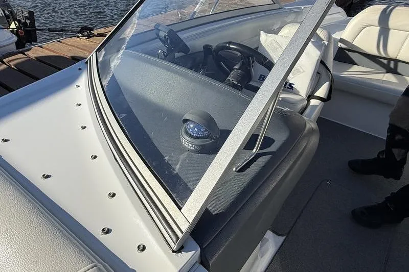 Slide: The Image of 2008 Cobalt 202 boat interior with steering wheel and compass, docked by the water. - 38