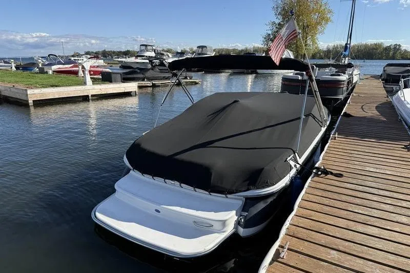 Slide: The Image of 2008 Cobalt 202 boat docked with cover, American flag, and scenic marina view. - 4