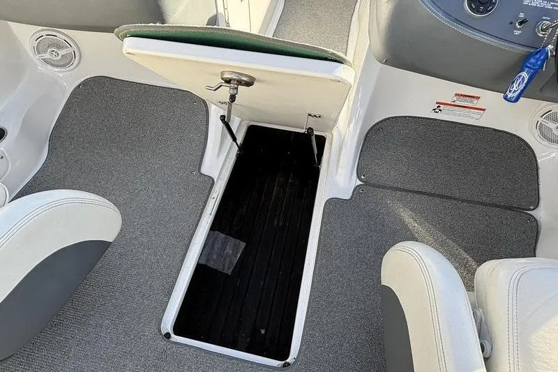 Slide: The Image of 2008 Cobalt 202 boat interior with open storage compartment and gray carpet. - 40