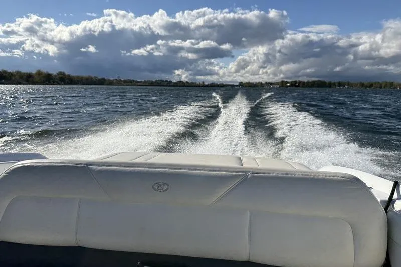 Slide: The Image of 2008 Cobalt 202 boat cruising on a lake, leaving a wake under a cloudy sky. - 43