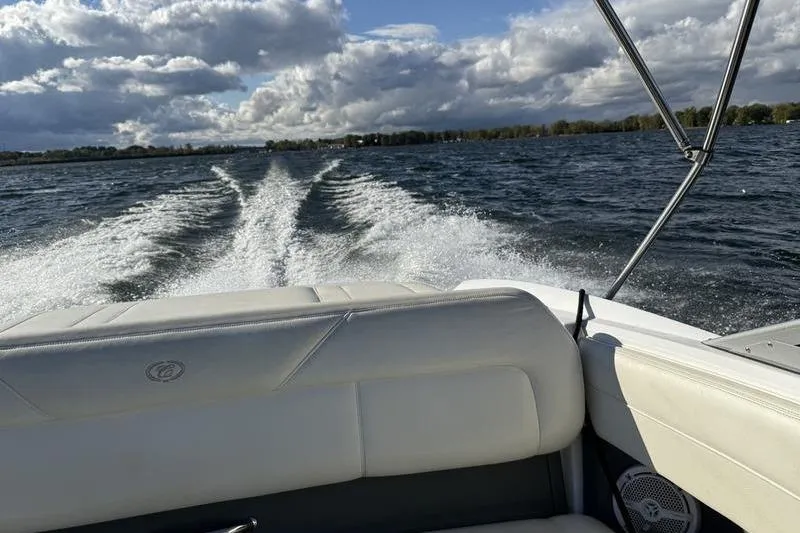 Slide: The Image of 2008 Cobalt 202 boat cruising on a lake, leaving a wake under cloudy skies. - 45