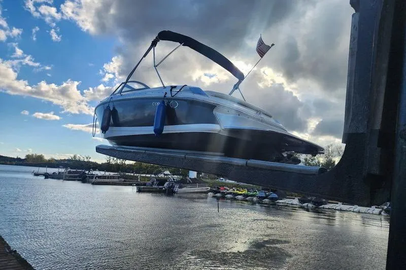 Slide: The Image of A 2008 Cobalt 202 boat being lifted at a marina under a cloudy sky. - 7