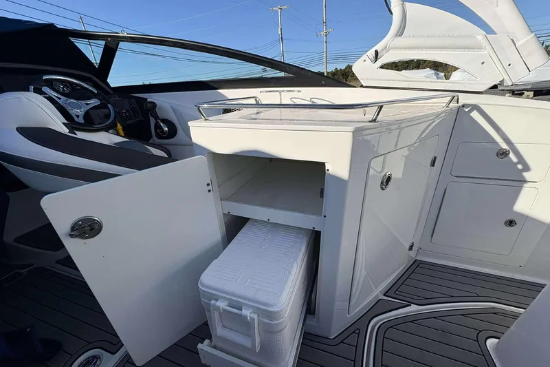 Slide: The Image of 2020 Monterey M-65 boat interior with open storage compartment and cooler. - 13
