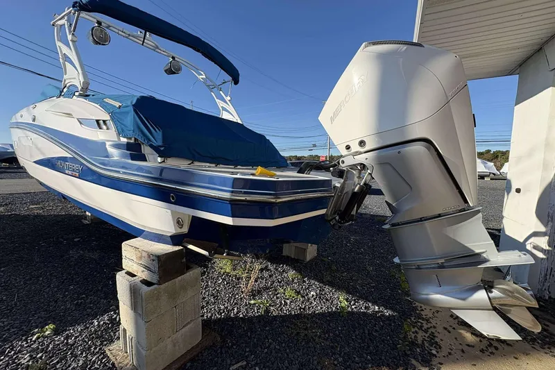 Slide: The Image of 2020 Monterey M-65 boat with Mercury outboard engine, elevated on blocks, blue and white design. - 6