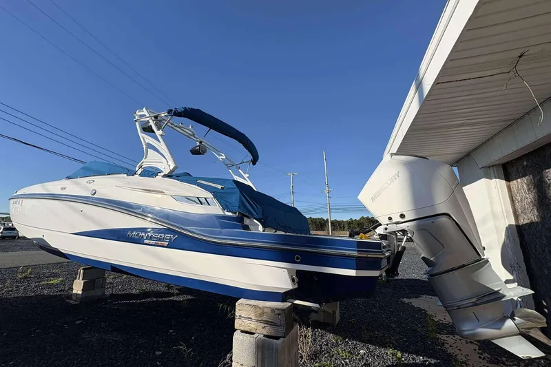 Slide: The Image of 2020 Monterey M-65 boat with Mercury engine, displayed outdoors on wooden supports. - 7