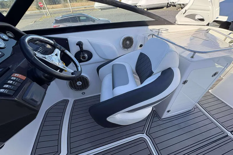 Slide: The Image of 2020 Monterey M-65 boat cockpit with steering wheel, controls, and cushioned seat. - 9