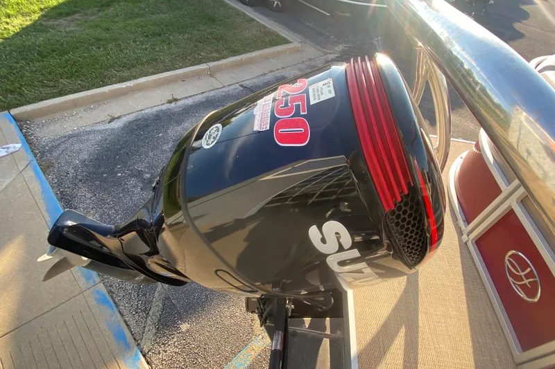 Slide: The Image of Outboard motor on a 2018 Hampton 2485 SE boat, parked on pavement. - 17