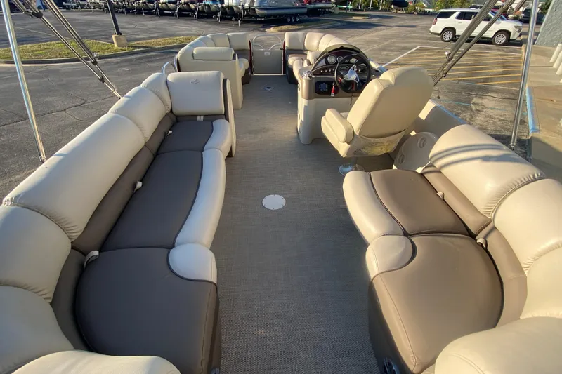 Slide: The Image of 2018 Hampton 2485 SE pontoon boat interior with plush seating and steering console. - 18