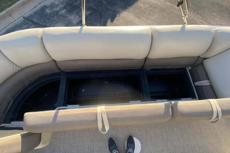 Slide: The Image of 2018 Hampton 2485 SE boat with open storage compartments and cushioned seating. - 20