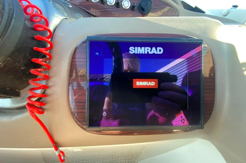 Slide: The Image of Simrad display on 2018 Hampton 2485 SE boat dashboard with red coiled cord. - 23