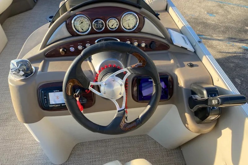 Slide: The Image of 2018 Hampton 2485 SE boat dashboard with steering wheel and control panel. - 26