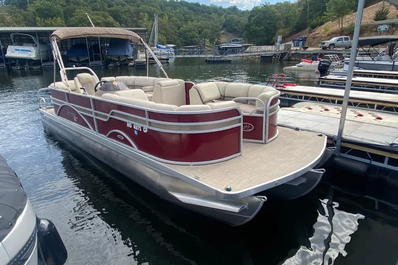 Slide: The Image of 2018 Hampton 2485 SE pontoon boat docked on a serene lake. - 32