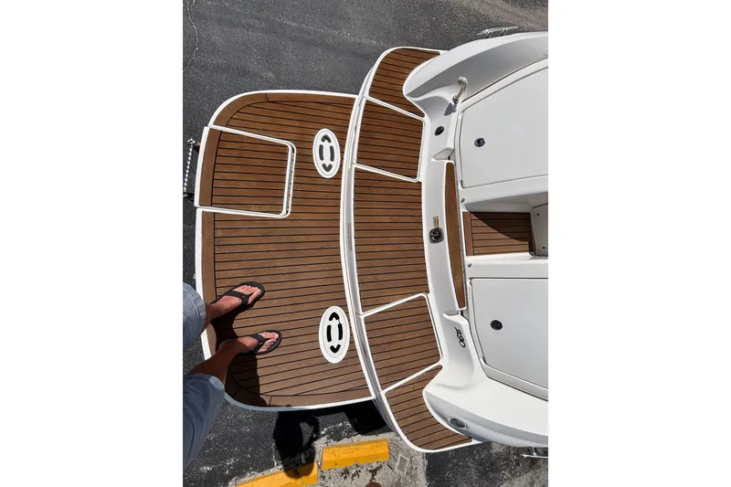 Slide: The Image of 2006 Sea Ray 290 SLX boat deck with teak flooring and person in sandals. - 10