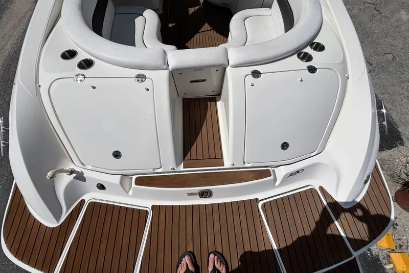 Slide: The Image of 2006 Sea Ray 290 SLX boat deck with white seating and wood flooring. - 12