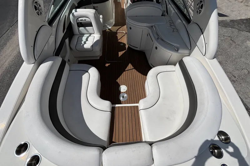 Slide: The Image of 2006 Sea Ray 290 SLX boat interior with white seating and wood flooring. - 14
