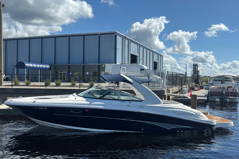 Slide: The Image of 2006 Sea Ray 290 SLX boat docked at marina under blue sky. - 2