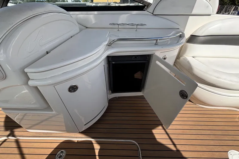 Slide: The Image of 2006 Sea Ray 290 SLX boat interior with open cabinet and sleek seating. - 23