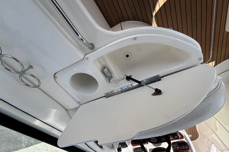 Slide: The Image of 2006 Sea Ray 290 SLX boat interior with open storage compartment and cup holders. - 24