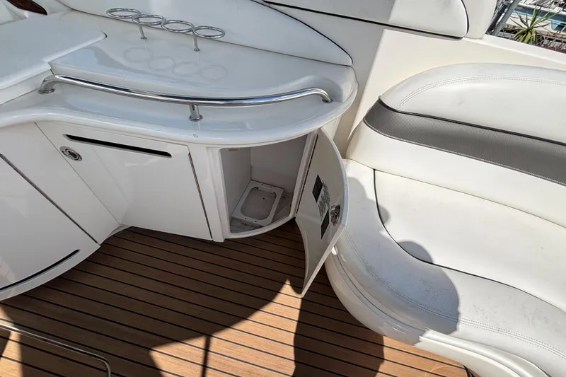 Slide: The Image of 2006 Sea Ray 290 SLX interior with white seating and open storage compartment. - 25