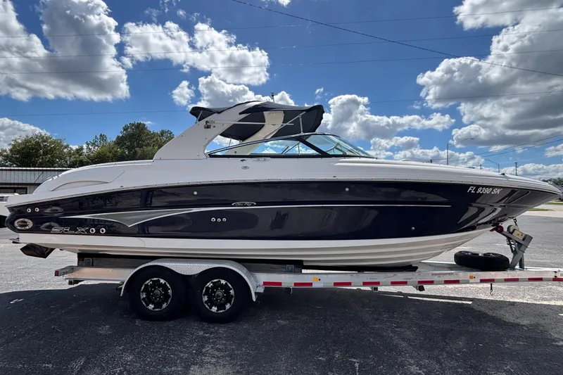 Slide: The Image of 2006 Sea Ray 290 SLX boat on trailer under a partly cloudy sky. - 3