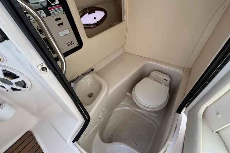 Slide: The Image of 2006 Sea Ray 290 SLX boat interior with compact bathroom and control panel. - 32