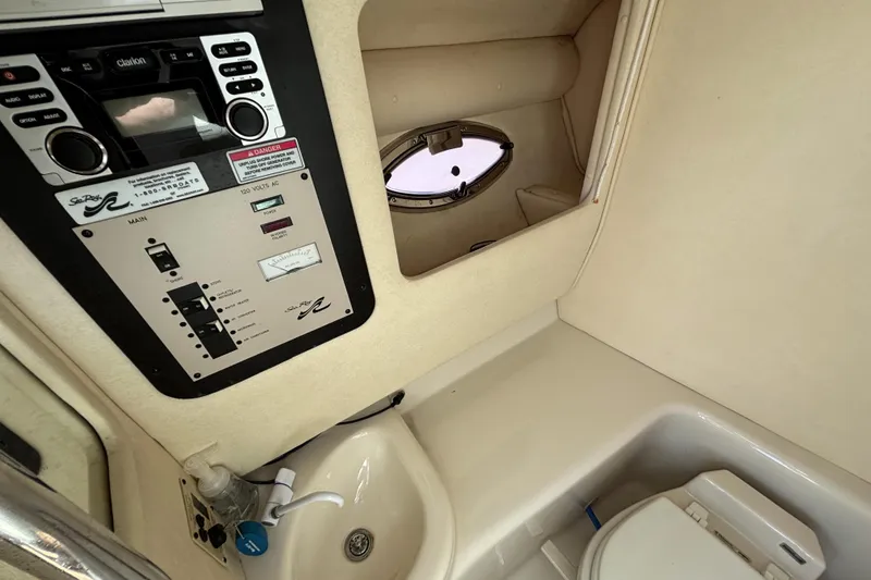 Slide: The Image of 2006 Sea Ray 290 SLX cabin interior with control panel, sink, and porthole. - 34