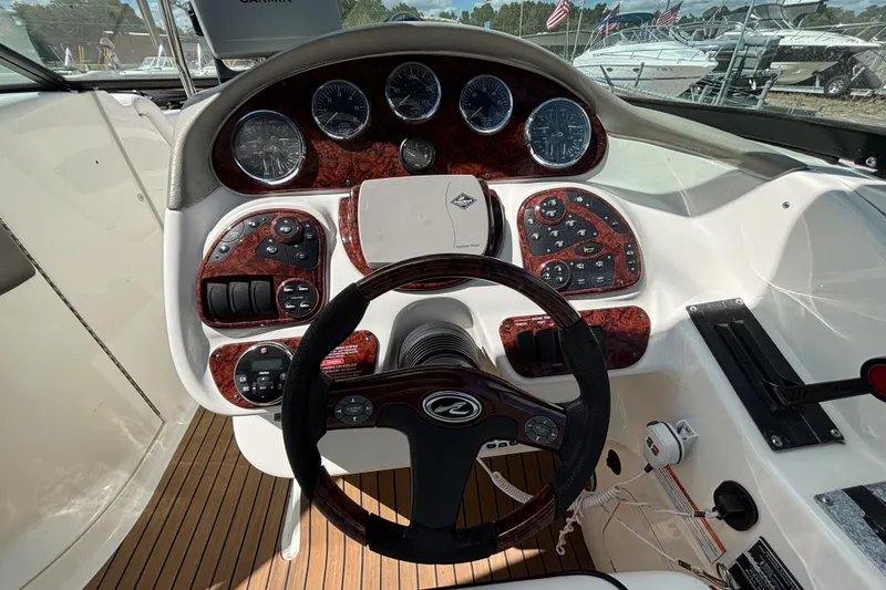 Slide: The Image of Steering console of a 2006 Sea Ray 290 SLX boat with wood accents and gauges. - 36