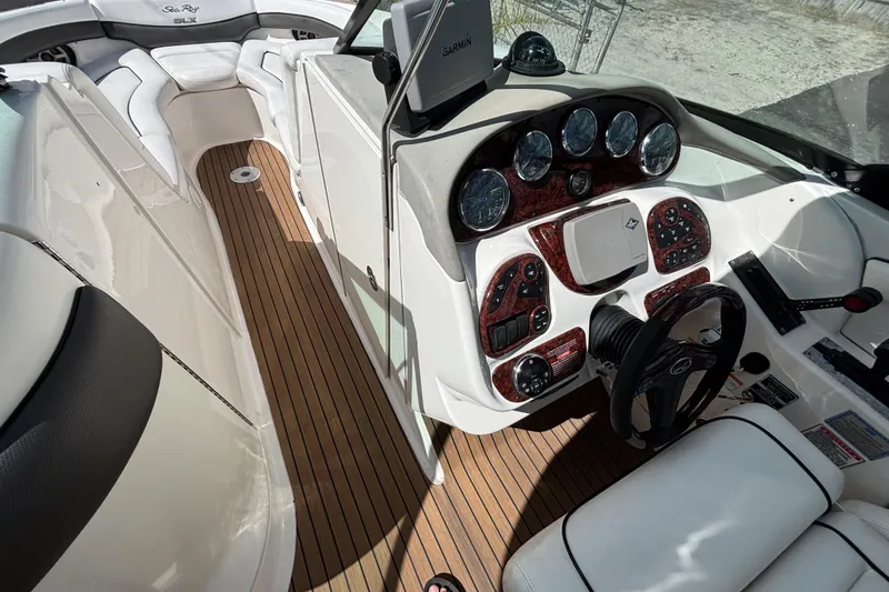 Slide: The Image of 2006 Sea Ray 290 SLX boat interior with sleek dashboard and wooden flooring. - 39