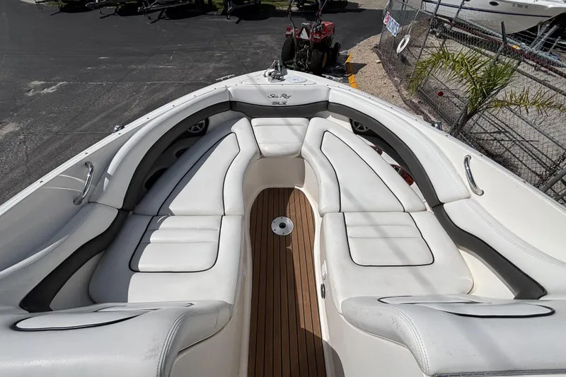 Slide: The Image of 2006 Sea Ray 290 SLX boat interior with white seating and wooden flooring. - 42