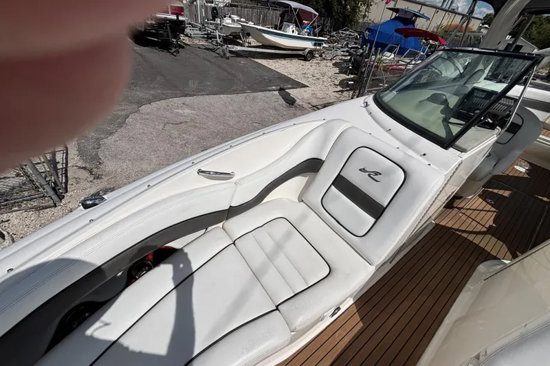 Slide: The Image of 2006 Sea Ray 290 SLX boat interior with white seating and wooden deck. - 45