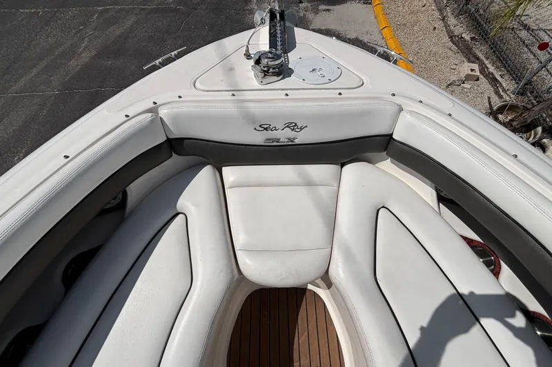 Slide: The Image of 2006 Sea Ray 290 SLX boat interior with white seating and wood flooring. - 46
