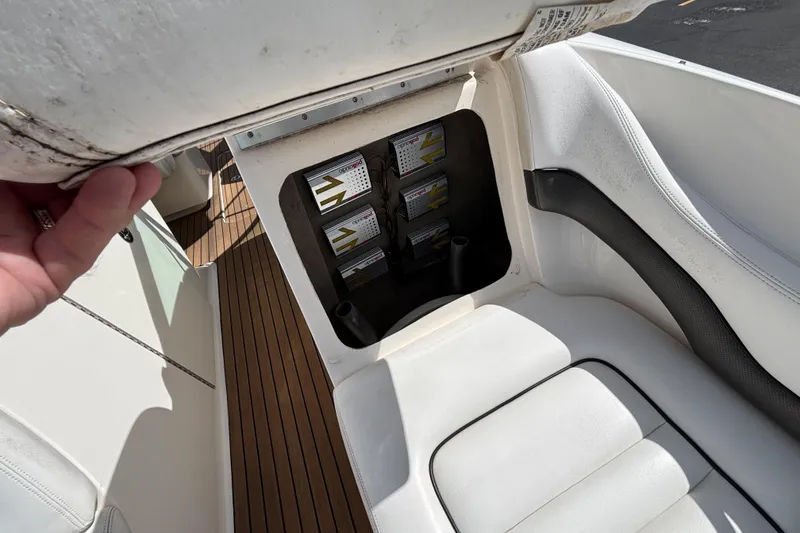 Slide: The Image of 2006 Sea Ray 290 SLX boat interior storage compartment with white seating and wooden flooring. - 56