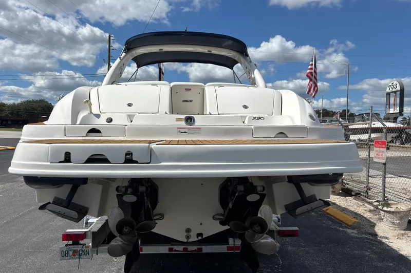 Slide: The Image of 2006 Sea Ray 290 SLX boat rear view with dual propellers, parked outdoors. - 6