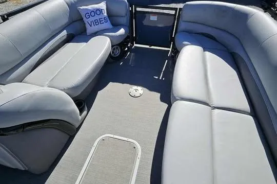 Slide: The Image of 2018 Regency 220 DL3 pontoon boat interior with gray seating and "Good Vibes" pillow. - 8