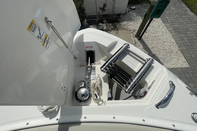 Slide: The Image of 2023 Boston Whaler 280 Vantage boat anchor compartment with ladder and equipment. - 13