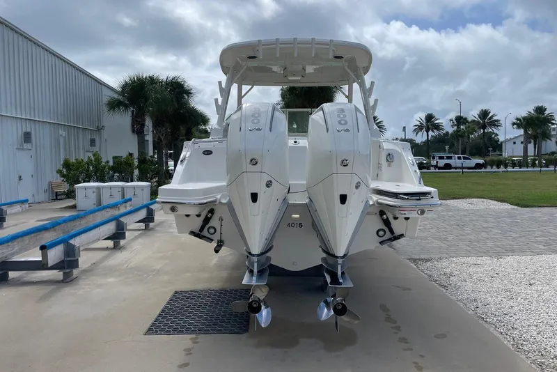 Slide: The Image of 2023 Boston Whaler 280 Vantage with dual outboard engines, parked outdoors. - 2