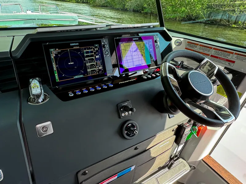 Slide: The Image of 2024 Axopar 37XC CROSS CABIN helm with advanced navigation displays and steering wheel. - 5
