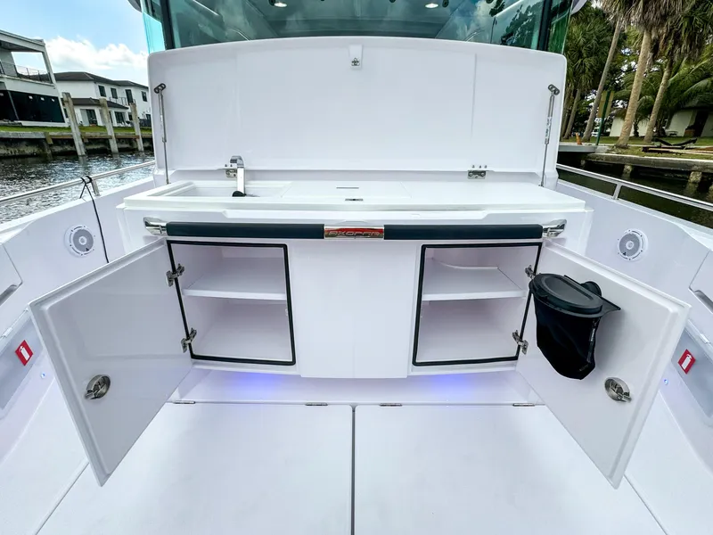Slide: The Image of 2024 Axopar 37XC CROSS CABIN boat interior with open storage compartments and sink. - 7