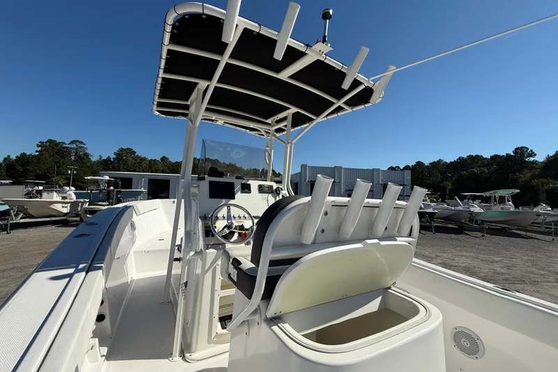 Slide: The Image of 2023 Clearwater boat interior with steering console and rod holders, parked outdoors. - 10