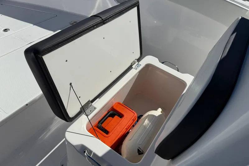 Slide: The Image of Open storage compartment on Clearwater boat, containing an orange toolbox and a white buoy. - 12