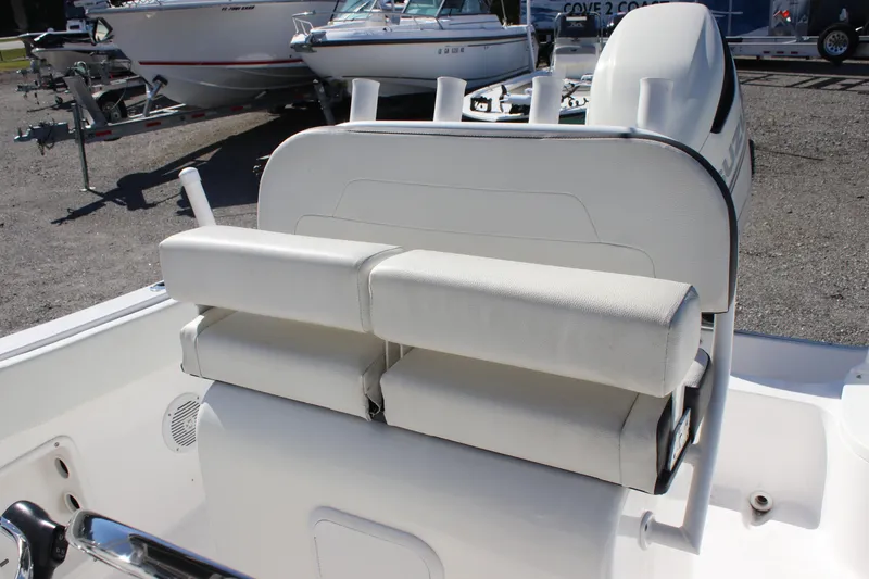 Slide: The Image of White Clearwater boat seat with cushioned backrest, 2023 model, in a marina setting. - 5