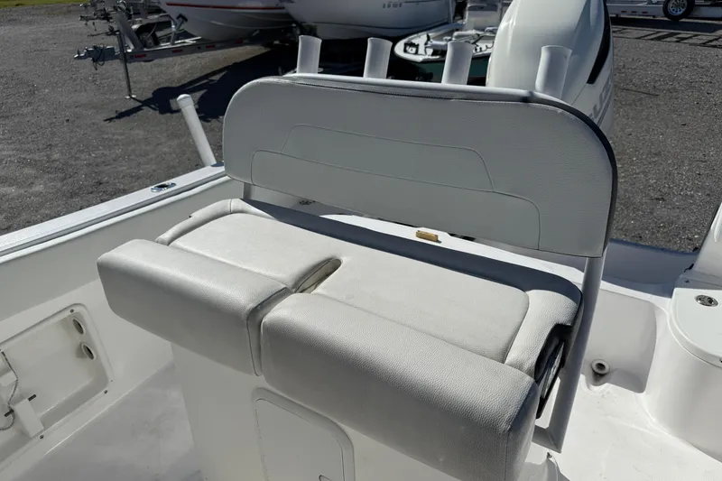Slide: The Image of White Clearwater boat seat with rod holders, 2023 model, in a sunny outdoor setting. - 8